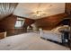 Spacious attic with wood paneled walls, window and ceiling fan at 1000 Lamond Ave, Durham, NC 27701
