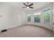 Bright bedroom features neutral carpet, updated ceiling fan, and three large windows with decorative trim at 1000 Lamond Ave, Durham, NC 27701
