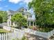 Classic two-story home with a porch, balcony, white picket fence, and lush greenery at 1000 Lamond Ave, Durham, NC 27701