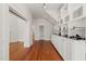 Spacious hallway with hardwood floors, large built in shelving unit, and white trim throughout at 1000 Lamond Ave, Durham, NC 27701