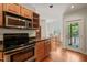 Warm kitchen featuring wood cabinets and stainless steel appliances leading to a dining area at 1000 Lamond Ave, Durham, NC 27701