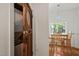 A stacked washer and dryer in a laundry area with a rustic wood door and a dining area visible in the background at 1000 Lamond Ave, Durham, NC 27701