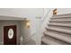Carpeted stairs with white banister lead to a door and lower level of the home at 1000 Lamond Ave, Durham, NC 27701