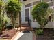 Enclosed porch with steps leading up and a black railing, framed by trees and gardens at 10003 Fountain, Chapel Hill, NC 27517