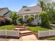 Charming home featuring a manicured lawn, brick stairs, white picket fence, and inviting front porch with columns at 10003 Fountain, Chapel Hill, NC 27517