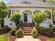 Charming home exterior showcasing a brick stairway, covered entryway, and manicured landscaping at 10003 Fountain, Chapel Hill, NC 27517