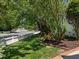 Well-manicured front yard with mature trees and landscaping along a street with a white picket fence at 10003 Fountain, Chapel Hill, NC 27517
