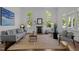 Bright living room with a decorative fireplace, large windows, and stylish, neutral-toned furnishings at 10003 Fountain, Chapel Hill, NC 27517