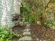 Stone pathway leading through a landscaped side yard, enhanced by natural foliage and mulch at 10003 Fountain, Chapel Hill, NC 27517