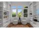 Cozy sitting area with built-in bookshelves, large windows, and comfortable seating for reading and relaxation at 10003 Fountain, Chapel Hill, NC 27517