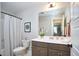 A well-lit bathroom featuring a single vanity, a toilet, mirror, and a shower with a curtain at 1021 Greatland Rd, Durham, NC 27703