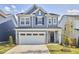 Charming two-story home features a two-car garage, lovely landscaping, and a classic blue exterior at 1021 Greatland Rd, Durham, NC 27703