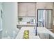 Modern kitchen with stainless steel refrigerator, island sink, white countertops and gray cabinets with gold hardware at 1021 Greatland Rd, Durham, NC 27703