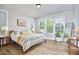 Bright main bedroom features large windows with blinds, hardwood floors, and neutral-toned decor at 1021 Greatland Rd, Durham, NC 27703