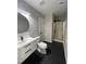 Modern bathroom with black tiled floors, gray walls, and glass shower door at 103 Romaine Ct, Cary, NC 27513