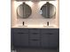 Bathroom vanity featuring double sink, gray cabinets, and modern round mirrors at 103 Romaine Ct, Cary, NC 27513