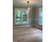 Dining room with modern chandelier and hardwood flooring with large windows at 103 Romaine Ct, Cary, NC 27513