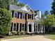 Beautiful two-story brick home with black shutters and a well-maintained lawn under a blue sky at 103 Romaine Ct, Cary, NC 27513