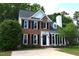 Charming two-story brick home with black shutters, manicured landscaping, and a paved driveway at 103 Romaine Ct, Cary, NC 27513
