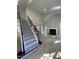 Light-filled foyer with hardwood floors and carpeted stairs with wrought iron railing near a modern fireplace at 103 Romaine Ct, Cary, NC 27513