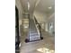 Bright foyer with high ceilings, wood floors, and carpeted stairs with dark wood and wrought iron railing at 103 Romaine Ct, Cary, NC 27513