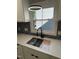 Kitchen sink and window above with quartz countertops and hexagonal backsplash tiles at 103 Romaine Ct, Cary, NC 27513