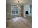 Open concept to living room with a fireplace, hardwood flooring and a modern chandelier at 103 Romaine Ct, Cary, NC 27513