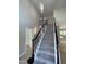 Carpeted staircase with dark wood and wrought iron railing in a spacious, light-filled foyer at 103 Romaine Ct, Cary, NC 27513