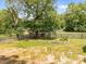 Lush backyard featuring a well-maintained lawn, mature trees, and a wooden fence at 104 Anderson Park Dr, Wake Forest, NC 27596