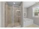 Bathroom showcasing a glass-enclosed shower and a luxurious soaking tub for ultimate relaxation at 104 Anderson Park Dr, Wake Forest, NC 27596