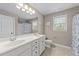 Bright bathroom with double vanity sinks, tiled floors, and neutral wall color at 104 Anderson Park Dr, Wake Forest, NC 27596