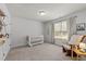 Relaxing bedroom with crib, glider and curtains, with neutral wall color at 104 Anderson Park Dr, Wake Forest, NC 27596