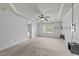 Large bedroom featuring a tray ceiling, ceiling fan, and a view into an ensuite bathroom for added convenience at 104 Anderson Park Dr, Wake Forest, NC 27596