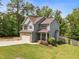 Charming two-story home with stone accents, gray siding, and a well-manicured lawn and fenced-in backyard at 104 Anderson Park Dr, Wake Forest, NC 27596