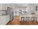 Well-lit kitchen featuring white cabinets, granite countertops, stainless steel appliances, and a convenient breakfast bar at 104 Anderson Park Dr, Wake Forest, NC 27596
