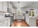 Bright kitchen boasts white cabinets, granite counters, stainless appliances, island with seating, and access to the dining area at 104 Anderson Park Dr, Wake Forest, NC 27596