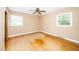 Bedroom features hardwood floors, two windows, and ceiling fan at 1041 Davis Dr, Apex, NC 27523