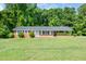 Charming single-story brick home featuring a well-manicured lawn and mature trees at 1041 Davis Dr, Apex, NC 27523
