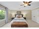 Cozy bedroom with a ceiling fan, light walls, a window and a side table with a lamp at 105 Sundew Ln, Cary, NC 27518