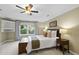 Cozy bedroom with a ceiling fan, light walls, a window and a side table with a lamp at 105 Sundew Ln, Cary, NC 27518