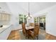 Sunlit dining area with a wooden table, chandelier, and sliding door at 105 Sundew Ln, Cary, NC 27518
