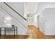 Spacious entryway featuring beautiful floors, a staircase, a decorative light fixture, and a modern glass table at 105 Sundew Ln, Cary, NC 27518