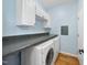 Functional laundry room with modern washer and dryer, ample counter space, and storage cabinets at 105 Sundew Ln, Cary, NC 27518