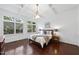 Bright main bedroom featuring large windows, tray ceilings, hardwood floors and a decorative light fixture at 105 Sundew Ln, Cary, NC 27518