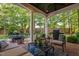 Inviting covered patio with ample seating, a grill and serene views of the landscaped yard at 106 Clendenen Ct, Cary, NC 27513