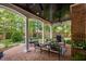 Elegant covered patio with white pillars, outdoor seating, a grill, and a serene backyard view at 106 Clendenen Ct, Cary, NC 27513