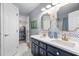 Bathroom featuring dual sink vanity, gold framed mirrors, and striking blue and white wallpaper at 106 Clendenen Ct, Cary, NC 27513