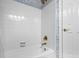 Clean bathtub and shower featuring bright white tile and gold fixtures in the bathroom at 106 Clendenen Ct, Cary, NC 27513