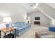 Bright bonus room with comfortable blue gingham couch, ceiling fan, and hardwood furniture at 106 Clendenen Ct, Cary, NC 27513