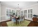 Bright dining room with hardwood floors, area rug, a chandelier, and shuttered windows at 106 Clendenen Ct, Cary, NC 27513